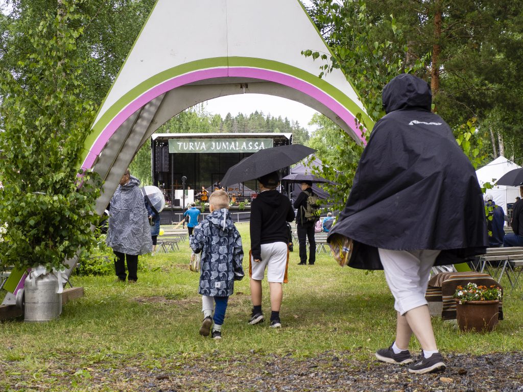 Ihmisiä kulkee sisään juhlaportista.