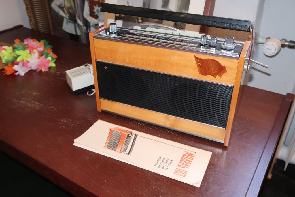 Kuvassa on vanha radio ja sen edessä radion venäjänkielinen käyttöopas.