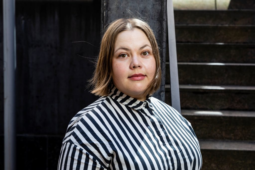 puolilähikuva naisesta joka katsoo suoraan kameraan