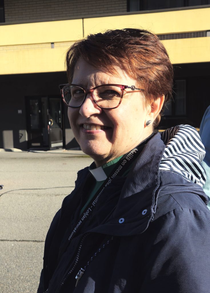 Puolilähikuvassa on silmälasipäinen nainen