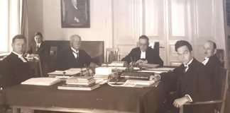 Mysteerikuva: Keitä ovat vakavat miehet pöydän ääressä?