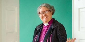 Valokuvataiteilija teki Irja Askolasta muotokuvan, jossa piispa avaa oven vihreään huoneeseen