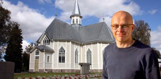 Kälviän seurakunnan kirkkoherra Jari Kolmonen: Numerot antavat vastapainoa hengelliseen työhön Kälviän kirkko taustalla , etualalla kirkkoherra Jari Kolmonen