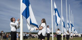 Suviseuroissa luvattiin Jumalan lapsiksi puhutellulle juhlakansalle, ettei taivaassa tarvitse enää taistella Suviseuroissa Suomen lippuja nostetaan pitkään riviin lipputankoja.