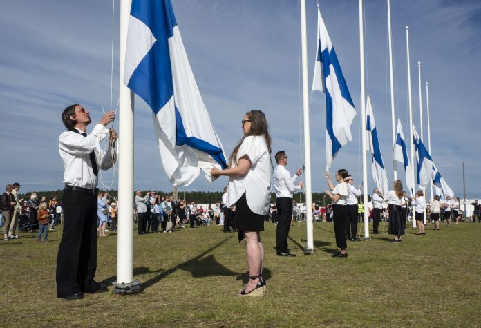 Suviseurat Lopella 27.6.2025 Suviseuroissa Suomen lippuja nostetaan pitkään riviin lipputankoja.
