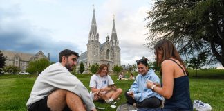 Pyhän Augustinuksen perilliset – Heitä ovat sekä Martti Luther että paavi Leo XIV Neljä nuorta istuu nurmikolla takanaan suuri keskiaikainen katedraali.