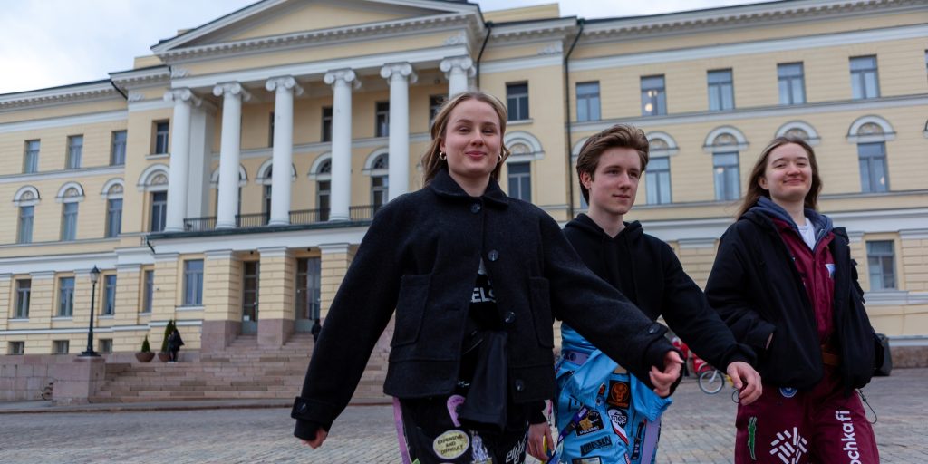 opiskelijoita haalareissaan Helsingin yliopiston päärakennuksen edustalla