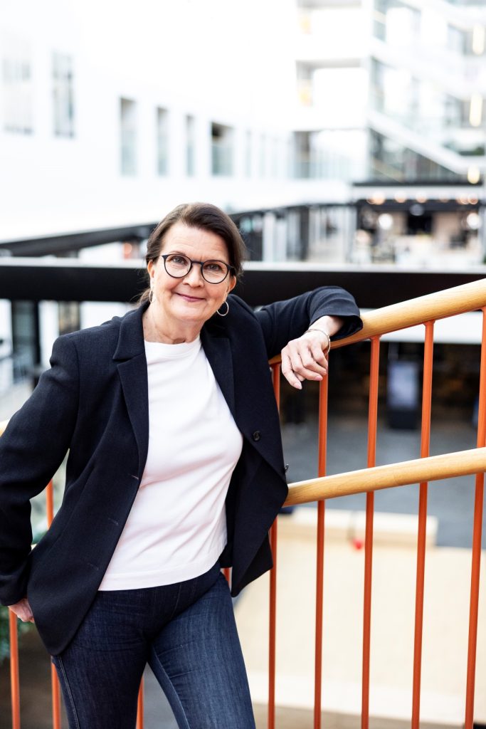nainen nojaa kyynärpäällään kaiteeseen