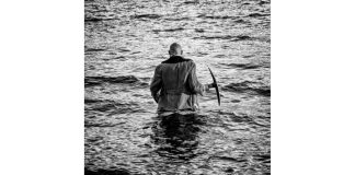 Levyarvio: Tuomiojärvi kuvaa maailman synkin sävyin Tuomiojärvi-levyn kansi kuvassa mies kävelee veteen