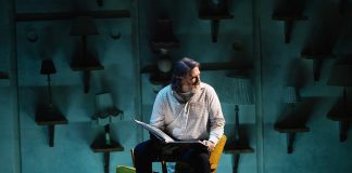 mies istuu näyttämöllä