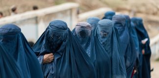 burkhaan pukeutuneita naisia jonossa