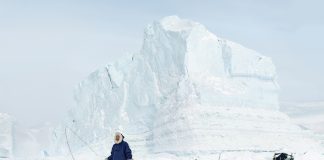 Tiina Itkosen Grönlanti-kuvat ovat hätähuuto jään ja tuulen maasta mies ja koiravaljakko jäävuoren edessä