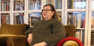 Anna-Riitta Mäki menetti pienenä äitinsä, mutta sai hyvän elämän ja 11 lasta Kuvassa vanhempi nainen istuu nojatuolissa yllään metsänvihreä villapaita. Takana näkyy kirjahyllyjä kirjoineen.