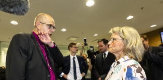 Oikeudessa syytettynä olevat Juhana Pohjola ja Päivi Räsänen seisovat vastakkain keskustelemassa vakavan oloisina.