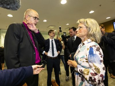 Oikeudessa syytettynä olevat Juhana Pohjola ja Päivi Räsänen seisovat vastakkain keskustelemassa vakavan oloisina.