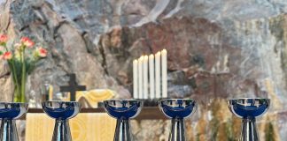 Näkökulma: Rituaalit rauhoittavat, vaikka usko horjuisi Ehtoollispikareita alttarikaiteella.