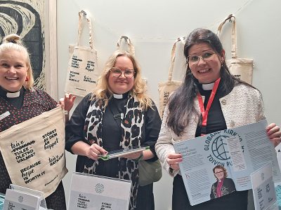 kolme naista katsoo suoraan kameraan ja esittelee markkinointimateriaaleja