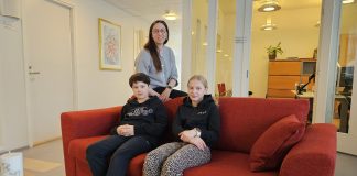 Raahen seurakunnan junnuryhmä tekee tilaa lasten äänelle Kolme henkilöä toimistomaisessa sisätilassa. Kaksi nuorta istuu punaisella sohvalla ja heidän takanaan seisoo aikuinen henkilö. Taustalla näkyy käytävä, toimistohuoneita lasiseinineen, valaisimia sekä seinällä kehystetty taulu.