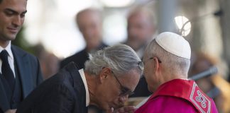 Paavi Leo, Andrea Bocelli ja 160 nuorta laulavat ja rukoilevat rauhan puolesta Mies suutelee paavin kättä.