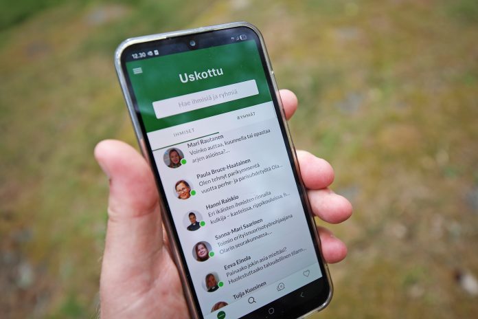 uskottu-sovellus kännykkä kädessä ja kännykässä näkyy uskottu-sovellus