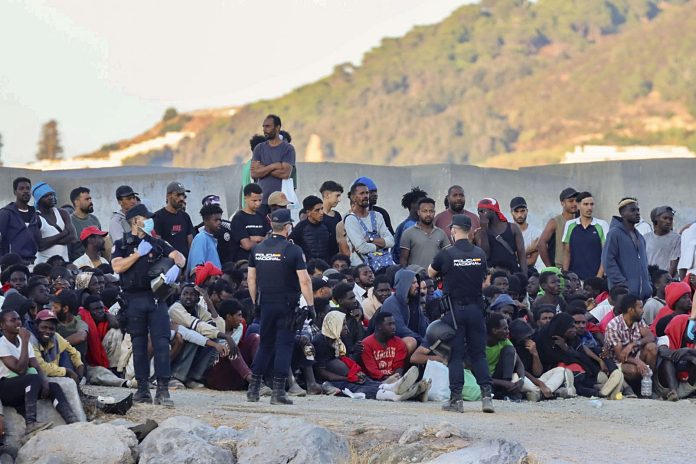Spain's Ceuta crisis following border rush from Morocco JOukko pakolaisia seisoo hiekkarannalla