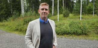 Isien uskon puolustaminen veti pappeja IKL:ään, Antti Malinen sanoo Kuvassa puolilähikuva miehestä jolla on harmaa villapaita ja valkoinen puvuntakki, taustalla näkyy puita ja nurmikkoa.
