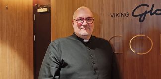 Kirkkoherra Teemu Salminen: Sanoma on selvä, mutta sitä on sanoitettava jatkuvasti uudelleen puolilähikuvba miespapista, joka nojaa seinään ja katsoo kameraan