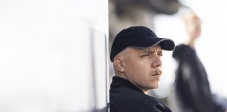 Aleksi Rantamaa vastusti kristinuskoa ja oli hyväksynyt kuolevansa alkoholismiin – nyt hän kertoo, mikä muutti kaiken Mustaan lippalakkiin ja takkiin pukeutunut viiksekäs mies nojaa vaaleaan seinään ja katsoo sivulle. Taustalla näkyy epätarkkana toinen tummaan asuun pukeutunut henkilö.