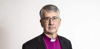 Piispa Salomäki: Emme voi tyytyä tilanteeseen, jossa ehtoollisyhteyttä ei ole Harmaahapsinen mies violetissa piispan pantapaidassa. Valkoinen tausta.
