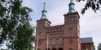 Tyrvään kirkkoon suunniteltu remontti ei kaikkia miellytä – ”Sopua pitäisi etsiä yhdessä keskustellen” Punatiilinen kirkkorakennus, jossa kaksi tornia, kirkkomaan takana.