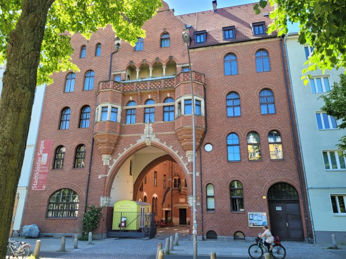 kaupunkiluostari_kadulta kuvattuna by Maarit Lukkarinen Iso punatiilinen, vanhan tyylinen rakennus kadun varressa.