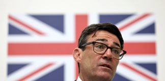 Hindu käy, katolinen ja juutalainen ei – Andy Burnham puuttui lakiin Englannin kirkon piispannimityksistä Mies seisoo Britannian lipun edessä.