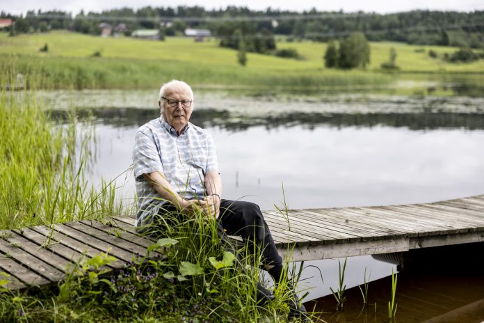 Reijo Arkkila Vanha mies istuu laiturilla veden äärellä.