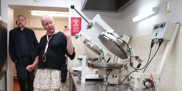 Ehtoollisleipiä Diakonissalaitokselta by Freija Özcan Nainen esittelee leipomiseen käytettäviä laitteita.