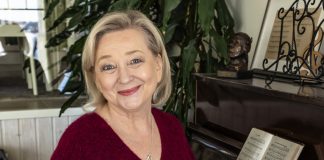 Kolumni: Eläkkeelläkin luotan, että tänään auttaa Herra Puolilähikuvassa vaaleahiuksinen nainen katsoo kameraa ja istuu pianotuolilla hymyillen.