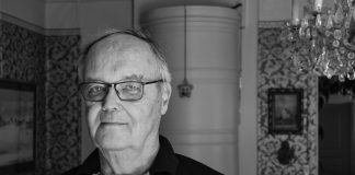 Piispa Jorma Laulaja on kuollut ALT-teksti: Silmälasipäinen mies katsoo kameraan mustavalkoisessa muotokuvassa. Taustalla näkyy koristeellisesti tapetoitu huone, tauluja ja kristallikruunu.