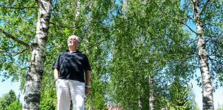 Arkistojuttu: Jorma Laulajan tie kulki maalaispapista piispaksi Iäkäs mies seisoo koivujen keskellä aurinkoisella pihalla. Hänellä on musta paita ja valkoiset housut, ja taustalla näkyy vehreää kasvillisuutta, hiekkatie ja rakennuksia.
