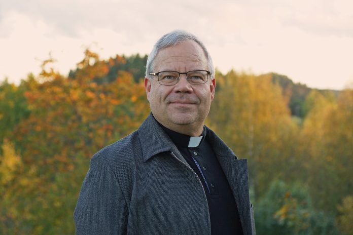 Miika Rosendal ulkona by Joel Rosendahl pappismies seisoo ulkona liperit kaulassa ja katsoo suoraan kameraan