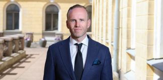 Oikeuskansleri huomautti ministeri Mika Poutalaa uskonnollisten järjestöjen avustuksista pukuun pukeutunut mies seisoo ryhdikkäästi ja katsoo suoraan kameraan