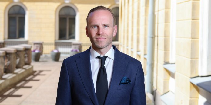 Mika Poutala-22 pukuun pukeutunut mies seisoo ryhdikkäästi ja katsoo suoraan kameraan