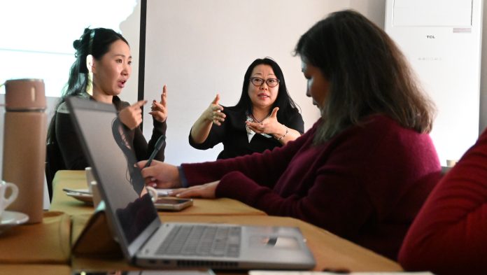 Mongolia viittomakieli toimintakuva Pöydän ääressä on kolme mongolialaista naista, jotka puhuvat viittomakieltä sekä läppäri.