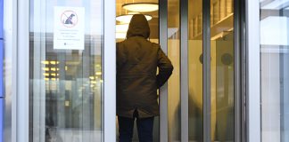 Väitöstutkimus: Turvapaikanhakijan uskonnollisen vakaumuksen arvioinnissa on vielä kehitettävää Huppupäinen mies kävelee ovesta sisään. Mies on kuvattu takaapäin.