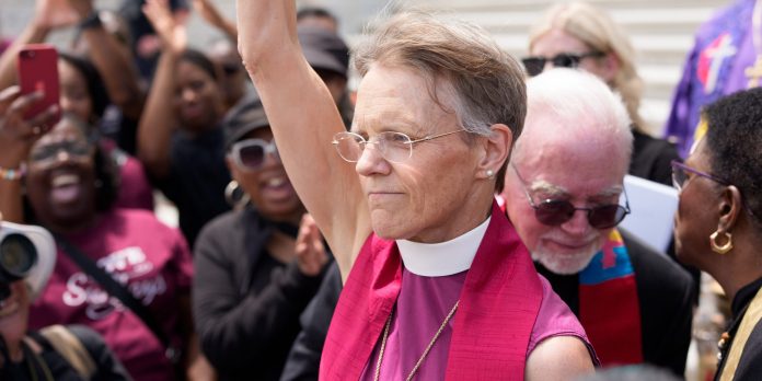 Moral Budget Vigil at US Capitol in Washington, District of Columbia, United States - 10 Jun 2025 Nainen hihattomassa piispanpaidassa huiskuttaa väkijoukolle.