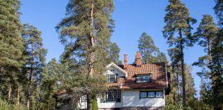 kuvassa on hieno, vanha huvila metsän keskellä