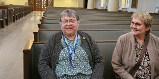 Kuvassa kaksi naista istuu kirkon etupenkissä