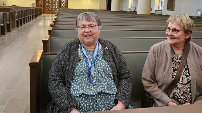 Jaana Kruth ja Kaarina Srkiluoto 3 by Emilia Karhu Kuvassa kaksi naista istuu kirkon etupenkissä