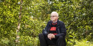 Paavo Kettunen teki tutkimusmatkan syyllisyyden ja kelpaamattomuuden kautta häpeän selättävään armoon Valkohiuksinen, silmälasipäinen mies istuu kivellä vehreässä metsämaisemassa. Hänellä on tumma takki ja punamustaraidallinen paita. Mies pitää käsiään ristissä polvien välissä ja katsoo hieman sivulle. Ympärillä kasvaa koivuja, pensaita ja ruohoa.