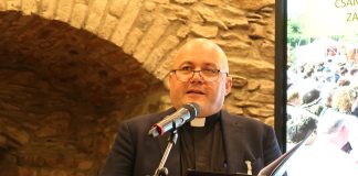 Romanian unkarilainen luterilainen apulaispiispa: ”Muotoileeko kirkko maailmaa vai maailman arvot kirkon uskoa?” Pappi musta paita yllään puhuu pöydän ääressä kirja kädessään.