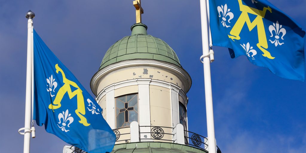 etualalla Turun kaupungin liput ja takana ortodoksisen kirkon kupoli