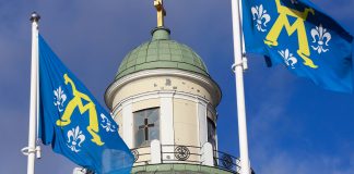 etualalla Turun kaupungin liput ja takana ortodoksisen kirkon kupoli